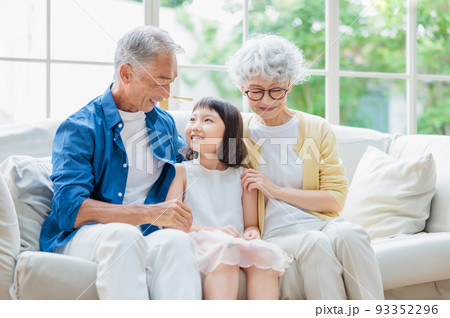 リビングでくつろぐシニア夫婦と孫 リビングでくつろぐシニア夫婦と孫 93352296