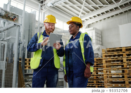 Young male engineer with tablet making presentation to female colleague Young male engineer with tablet making presentation to female colleague 93352706