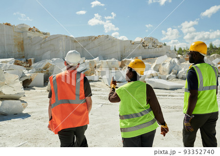 Group of young intercultural workers of marble quarry moving towards rocks Group of young intercultural workers of marble quarry moving towards rocks 93352740