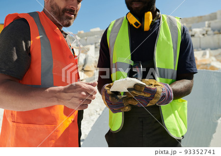 Mid section of two intercultural workers of marble quarry in uniform Mid section of two intercultural workers of marble quarry in uniform 93352741