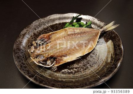 テーブルの上にあるDHAたっぷりの青魚をカットし天日干しした干物のアジの開き 93356389