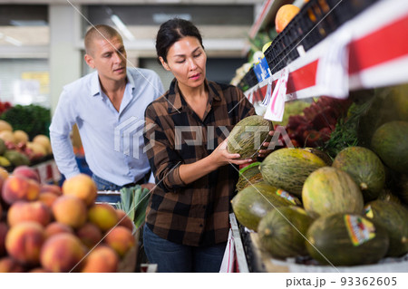 Woman and man choosing melons in supermarket Woman and man choosing melons in supermarket 93362605