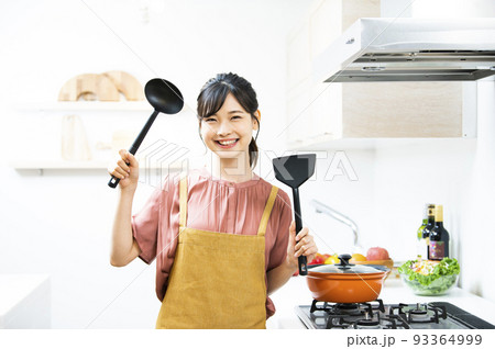 若い女性 料理 キッチン カメラ目線 笑顔 若い女性 料理 キッチン カメラ目線 笑顔 93364999