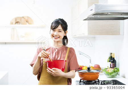 若い女性 料理 キッチン カメラ目線 笑顔 若い女性 料理 キッチン カメラ目線 笑顔 93365004