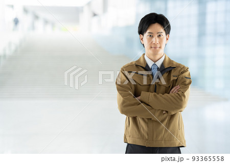 腕組みをする作業服の男性 93365558