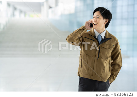 電話をする作業服の男性 電話をする作業服の男性 93366222