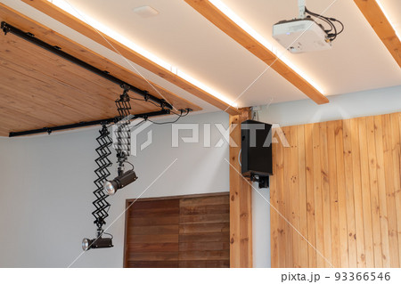 The Equipment of Seminar room; Black 2 Spotlights, speaker, and white projector are hanged on to ceiling and wall in the hall. 93366546