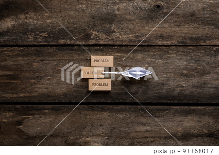 Origami boat dragging a wooden peg with the word Solution on it away from the Problem pegs 93368017