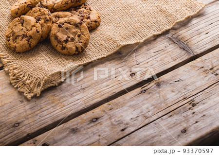 High angle view of cookies on burlap at wooden table, copy space High angle view of cookies on burlap at wooden table, copy space 93370597