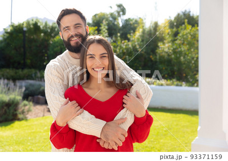 Portrait of happy caucasian couple standing in garden, smiling and embracing Portrait of happy caucasian couple standing in garden, smiling and embracing 93371159