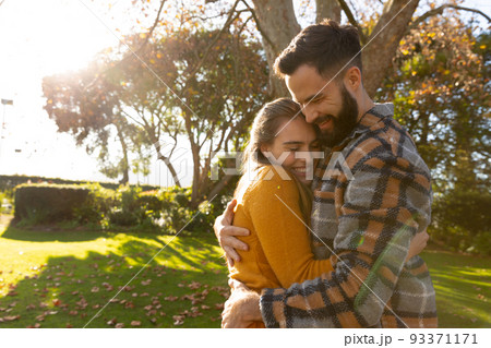 Image of happy caucasian couple hugging in autumn garden 93371171