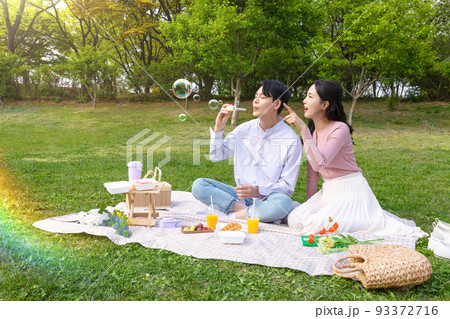 Asian Korean couple enjoying spring picnic_taking a selfie Asian Korean couple enjoying spring picnic_taking a selfie 93372716