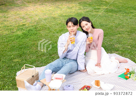 Asian Korean couple enjoying spring picnic_drinking beverage Asian Korean couple enjoying spring picnic_drinking beverage 93372872