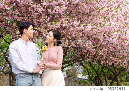 Korean Asian couple enjoying spring date_holding flowers Korean Asian couple enjoying spring date_holding flowers 93372951