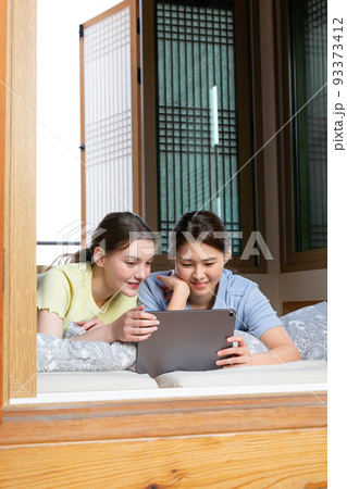 Experience Hanok, Korean traditional house_Korean and Caucasian girls watching video on tablet pc 93373412