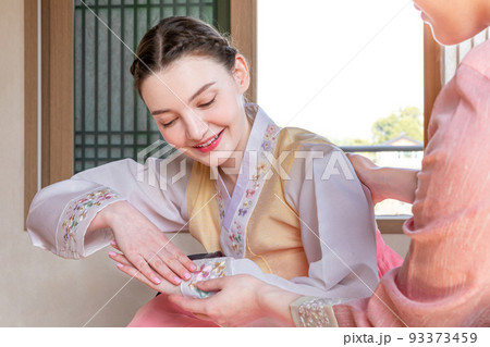 Experiencing Korean traditions in Hanok_Korean girl teaching Caucasian girl how to bow Experiencing Korean traditions in Hanok_Korean girl teaching Caucasian girl how to bow 93373459
