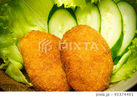 今日の晩ごはんは、カラッときつね色に揚がったコロッケと葉物野菜のレタス・きゅうり 93374401