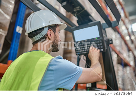 Experienced warehouse employee operating the electric lift truck Experienced warehouse employee operating the electric lift truck 93378064