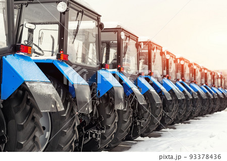 Many different tractors standing in row at agricultural fair for sale outdoors.Equipment for agriculture.Heavy industrial machines presented to agricultural exhibition. Agribusiness leasing concept 93378436