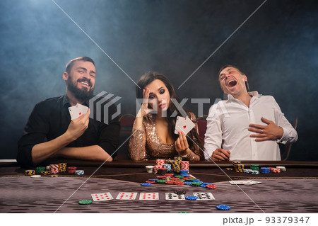 Group of a young rich friends are playing poker in casino. Group of a young rich friends are playing poker in casino. 93379347