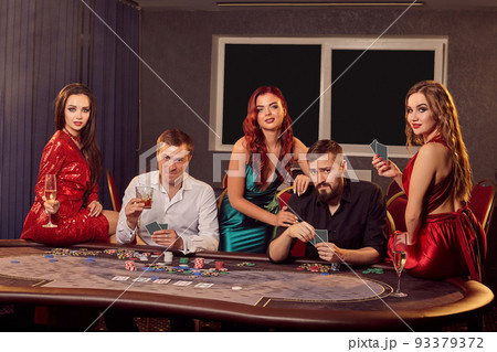 Group of a young rich friends are playing poker in casino. 93379372