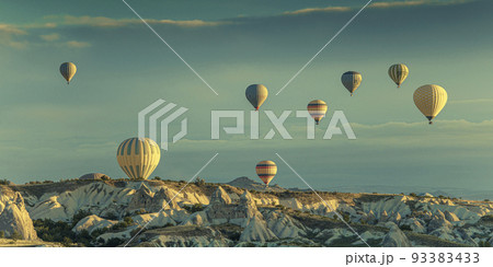 hot air balloons fly over goreme at dawn. 93383433