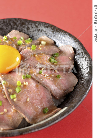 生卵の黄身と万能ねぎ、白胡麻が乗っているローストビーフ丼 生卵の黄身と万能ねぎ、白胡麻が乗っているローストビーフ丼 93383728