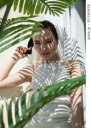 beautiful woman in the shade of palm leaves 93384858