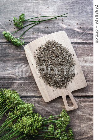 Dill seeds and flowers, Anethum graveolens on wooden background, overhead flat lay, vertical frame 93388692