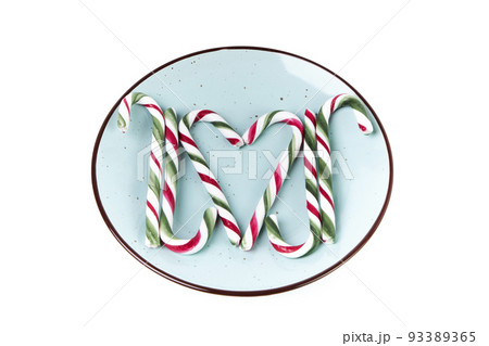 Christmas candy canes on a green plate making shapes. Christmas concept 93389365