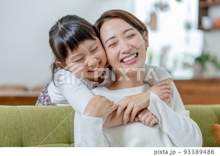 後ろからママに抱きつく小学生の女の子 後ろからママに抱きつく小学生の女の子 93389486