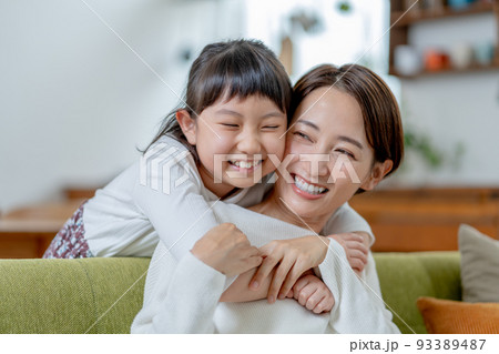 後ろからママに抱きつく小学生の女の子 後ろからママに抱きつく小学生の女の子 93389487