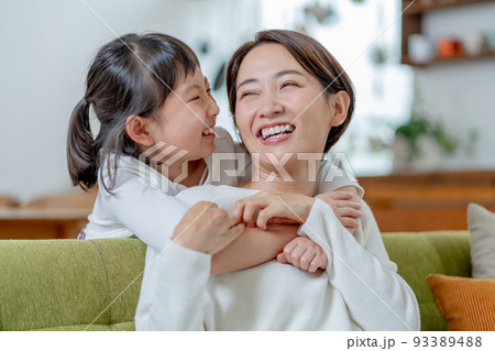 後ろからママに抱きつく小学生の女の子 後ろからママに抱きつく小学生の女の子 93389488