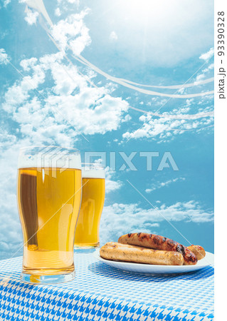 Glasses of cold frothy light beer and plate with fried sausages over blue sky background. Vacation, happiness, Oktoberfest vibes and ad concept. Retro style Glasses of cold frothy light beer and plate with fried sausages over blue sky background. Vacation, happiness, Oktoberfest vibes and ad concept. Retro style 93390328