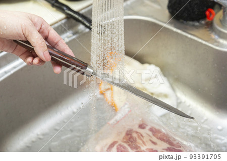 包丁を洗う女性の手元 93391705