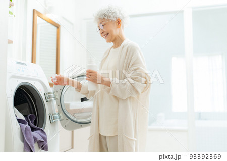 洗濯洗剤を洗濯機に入れるシニア女性 93392369