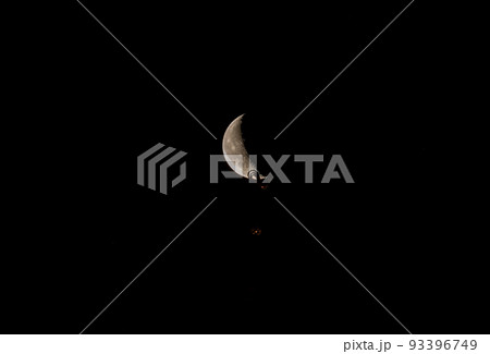 Beautiful orange quarter moon in the dark night sky over Riga city. 93396749