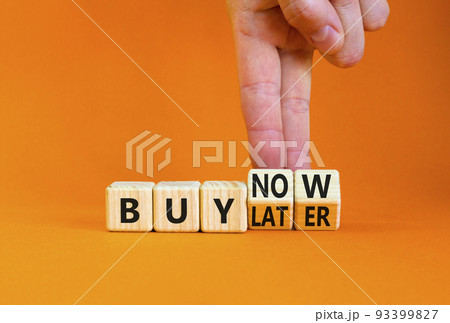 Buy later or now symbol. Businessman turns wooden cubes and changes concept words Buy later to Buy now. Beautiful orange table orange background. Business buy later or now concept. Copy space. 93399827