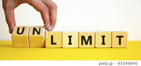 Limit or unlimit symbol. Businessman turns cubes, changes words 'limit' to 'unlimit'. Beautiful yellow table, white background, copy space. Business, limit or unlimit concept. 93399840