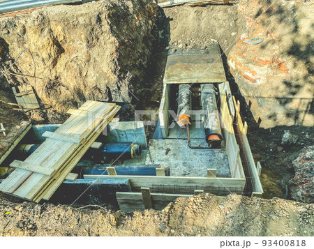 laying of underground communications for residential buildings. black plumbing pipes are buried underground on a wooden foundation to protect communications from pollution 93400818