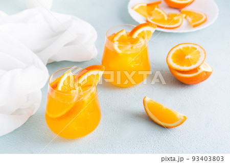 Hard seltzer cocktail with orange in glasses on the table. Homemade drink. 93403803