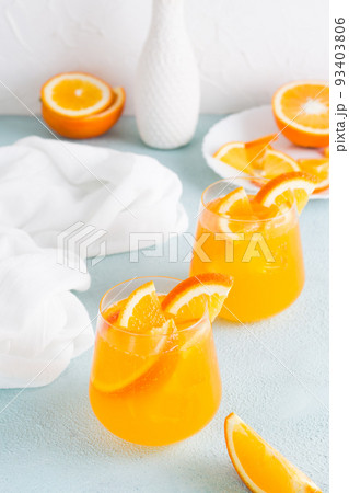 Hard seltzer cocktail with orange in glasses on the table. Homemade drink. Vertical view Hard seltzer cocktail with orange in glasses on the table. Homemade drink. Vertical view 93403806