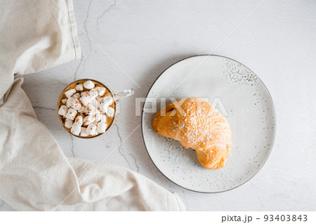 Fresh croissant on a plate and a big cup of coffee on the table. Homemade breakfast lifestyle. Top view 93403843