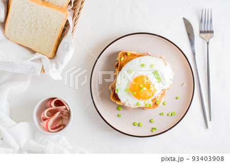 Homemade sandwich - croque madame on a plate on a light table. Top view 93403908