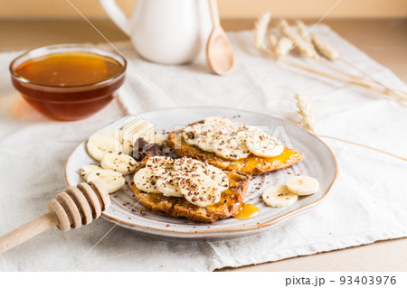 Ready to eat sandwiches with honey, banana and chocolate on a plate on the table. Homemade vegetarian snack 93403976
