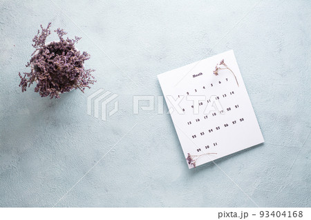 Blank sheet of the monthly calendar and a bouquet of dried flowers on the table. Time planning and organization 93404168