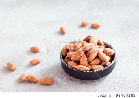 Fresh peeled almonds in a bowl on a light background. A source of vitamins and oils. Organic food Fresh peeled almonds in a bowl on a light background. A source of vitamins and oils. Organic food 93404185