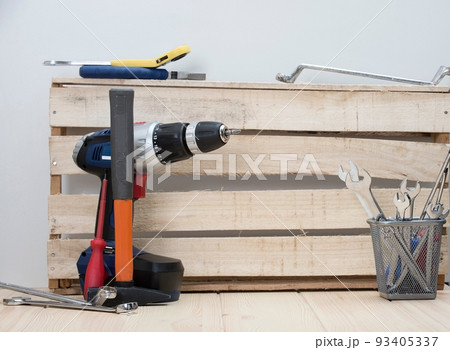 On the Labor Day the photo demonstrates wooden wall between a red hummer and vase full of different construction tools, ready to work. On the Labor Day the photo demonstrates wooden wall between a red hummer and vase full of different construction tools, ready to work. 93405337