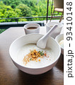 Minced Pork Congee with Soft Boiled Egg in bowl on wood table. 93410148