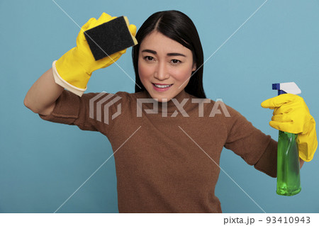 Smiling happy and joyful asian young woman holding a sponge with yellow gloves isolated on a blue background, Housewife worker, Cleaning home concept, Delighted laughing and positive state of mind Smiling happy and joyful asian young woman holding a sponge with yellow gloves isolated on a blue background, Housewife worker, Cleaning home concept, Delighted laughing and positive state of mind 93410943